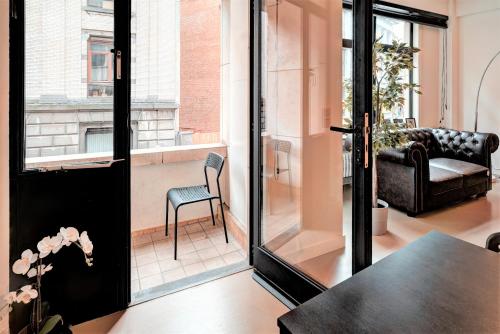 a living room with a glass door and a chair at Spacious Apartments in the Heart of Antwerp in Antwerp
