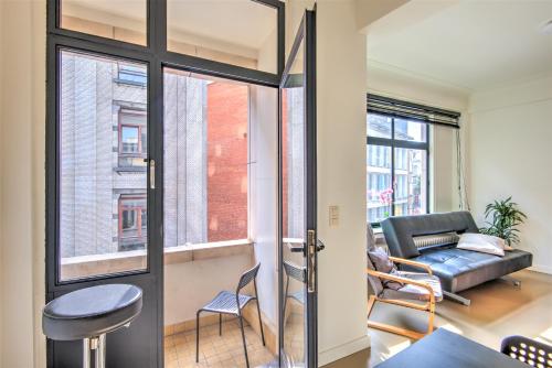 a living room with a door and a couch at Spacious Apartments in the Heart of Antwerp in Antwerp