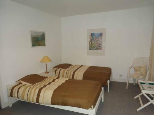 a hotel room with two beds and a chair at Charmante maison in Grand Bailly