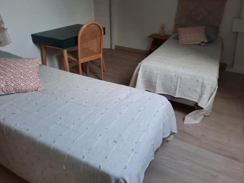 a room with two beds and a table and a desk at La bellangerie in Joue-les-Tours