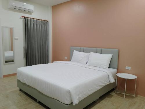 ein Schlafzimmer mit einem großen Bett mit weißer Bettwäsche und Kissen in der Unterkunft อาม่า อพาร์ทเมนต์ Ama Apartment in Ban Phai