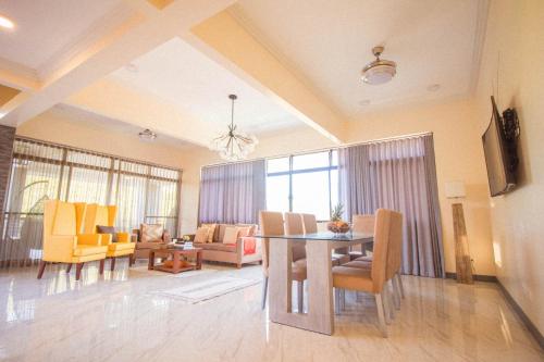 a living room with a table and yellow chairs at Bella Villa Coron in Coron