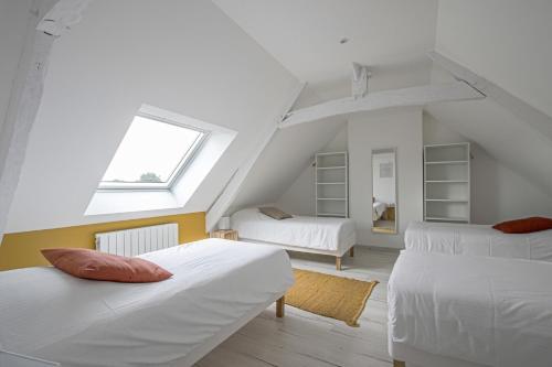 LingèvresにあるFerme de la Bertinièreの屋根裏のベッドルーム(ベッド2台、窓付)