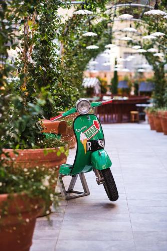 a small green scooter parked on a sidewalk at Mama Shelter Roma in Rome