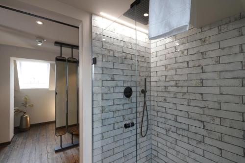 a bathroom with a white brick wall at REINHARDTs HOTEL in Buchen