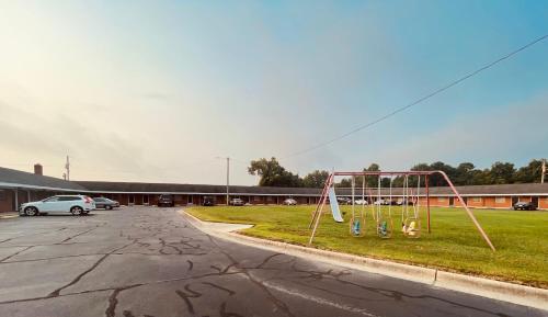 a swing set sitting in the middle of a parking lot at Deluxe inn in Wilson