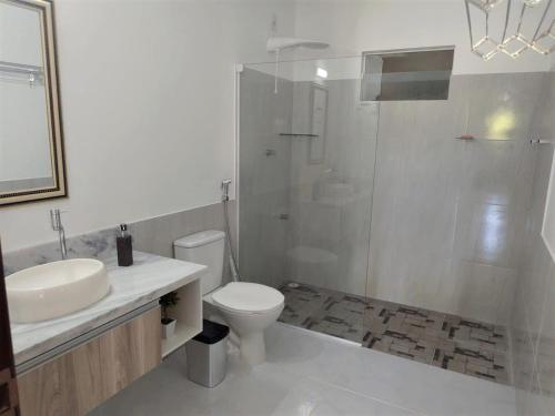 a bathroom with a toilet and a sink and a shower at EcoFlat Fiore I in Paripueira
