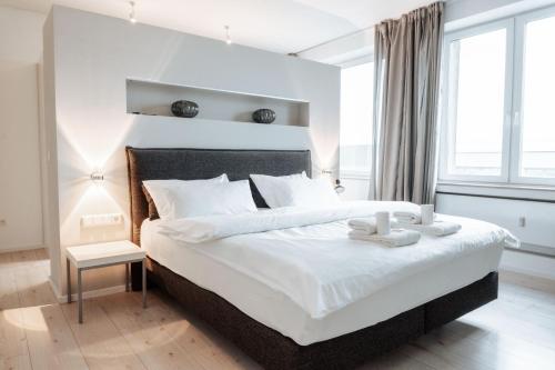 ミュンスターにあるLuxuriöses Loft über den Dächern Münsters 150 m²のベッドルーム(キャンドル付きの白い大型ベッド1台付)