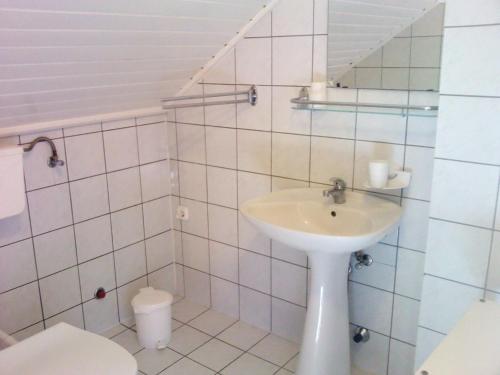 a white bathroom with a sink and a toilet at Napfény Apartment in Keszthely