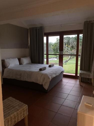 1 dormitorio con cama y ventana grande en San Lameer Holidays, en Southbroom