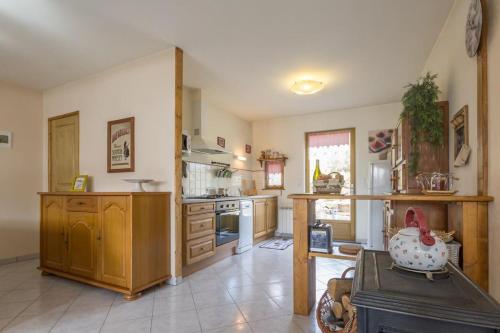 une grande cuisine avec des armoires en bois et une cuisinière dans l'établissement Les Pervenches, à Saint-Martin-de-la-Mer