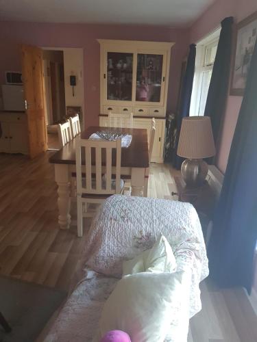 a living room with a table and a dining room at Hollybanks in Moycullen