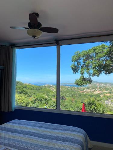 a bedroom with a bed and a large window at Top de Buzios Boutique Hotel & Spa in Búzios