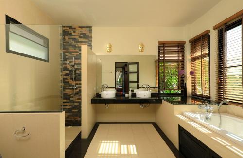 y baño con 2 lavabos y bañera. en VILLA SALIKA | 4 bedroom Thai Balinese private pool villa | Rawai, en Rawai Beach