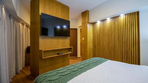 1 dormitorio con 1 cama y TV de pantalla plana en Salta Suite en Salta