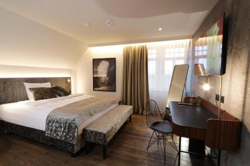 Pokój hotelowy z łóżkiem, biurkiem i biurkiem w obiekcie REINHARDTs HOTEL w mieście Buchen