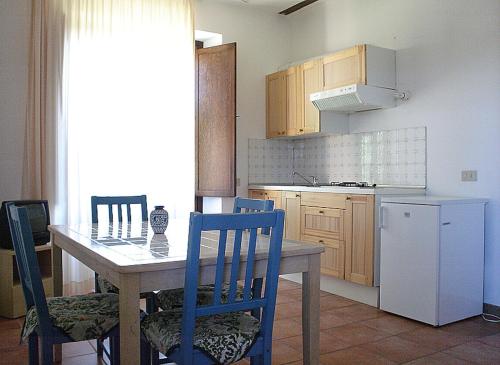 a kitchen with a table and chairs and a refrigerator at Podere Valmarina in Follonica
