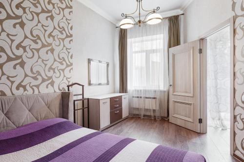 a bedroom with a bed and a sink and a mirror at One bedroom on Deribasovskaya in Odesa