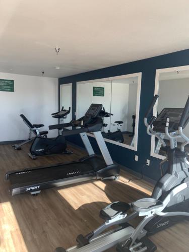 a gym with three exercise bikes and two mirrors at GreenTree Inn of Holbrook, AZ in Holbrook