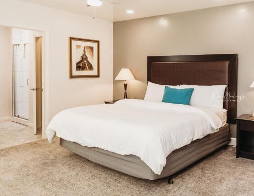 a bedroom with a large bed with white sheets and blue pillows at Hotel Phillips in Bartlesville