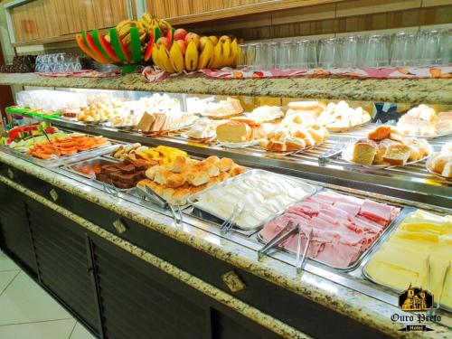 um buffet cheio de muitos tipos diferentes de alimentos em HOTEL OURO PRETO em Aparecida