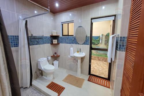 a bathroom with a toilet and a sink and a shower at LA BUENA VIDA CONDO in Tamarindo