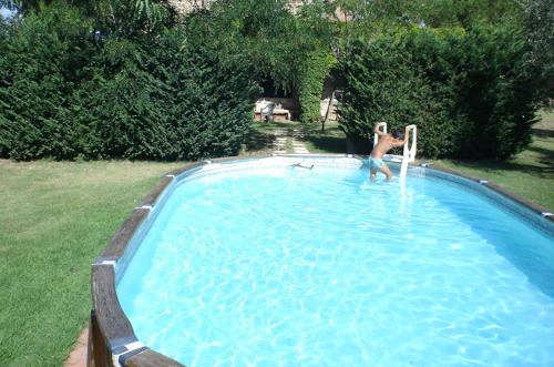 un hombre está jugando en una piscina en Podere Valmarina, en Follonica