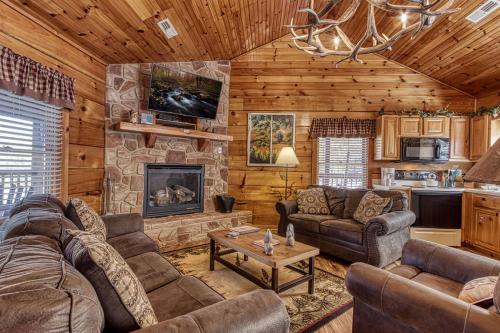 a living room with couches and a stone fireplace at The Nut House, Hot Tub, Game Room, WIFI, 560 FREE tickets each paid day in Pigeon Forge