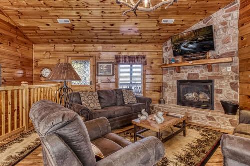 a living room with couches and a fireplace in a cabin at The Nut House, Hot Tub, Game Room, WIFI, 560 FREE tickets each paid day in Pigeon Forge