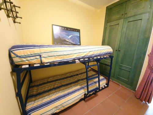 two bunk beds in a room with a green door at Loft Plaza Andalucía ERB Alojamientos in Sierra Nevada