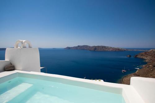 a swimming pool with a view of the ocean at Gabbiano Traditional Cave Houses in Oia