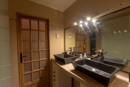 une salle de bain avec deux lavabos et un grand miroir dans l'établissement Very French Two Bedroom in the Heart of Paris, à Paris