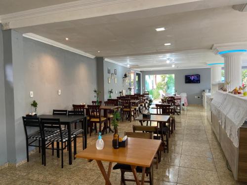 a restaurant with tables and chairs in a room at Pousada Maresia Costa Azul in Rio das Ostras