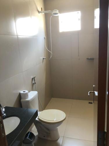 a bathroom with a shower and a toilet and a sink at Sunset Hotel in Carolina