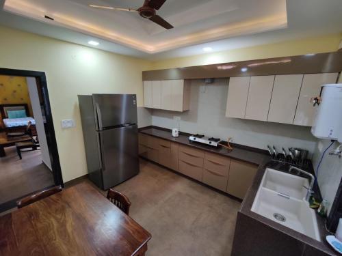 a kitchen with a stainless steel refrigerator and a table at Neetu's Home Stay in Jaipur