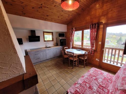 une cuisine et une salle à manger avec une table dans une cabine dans l'établissement Chalet Les Jonquilles, à La Bresse