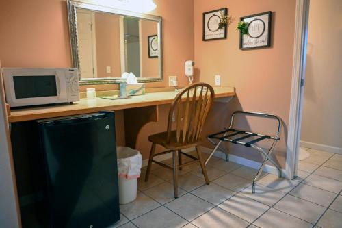 a kitchen with a desk with a microwave and a chair at The Adamina in Fairbanks