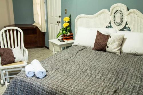 a bedroom with a large bed with two chairs at Hotel Casa Grande in San Miguel