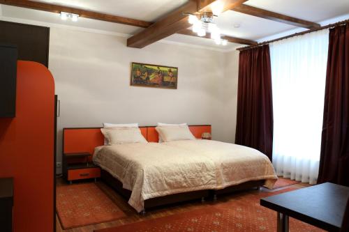 Hotel BACHUS في كيشيناو: غرفة نوم فيها سرير وطاولة فيها