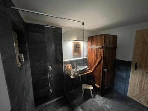 a bathroom with a shower with a sink and a wooden cabinet at Roubenka Jelen.ka in Rokytnice nad Jizerou