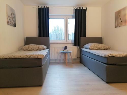 two beds in a room with a window at Nordunterkunft in Neumünster