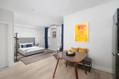uma sala de estar com uma mesa e uma cama em François-Denis Apartments em Montréal
