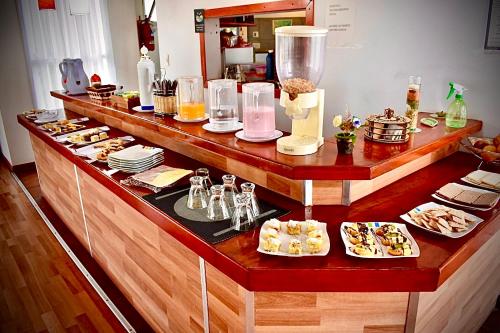 a buffet line with food and desserts on display at Hotel Colores in Merlo