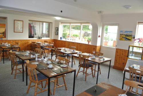 a dining room with wooden tables and chairs at Old Castle Farm Guest House in Brecon