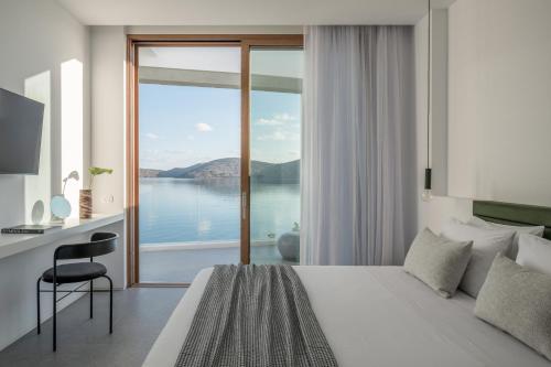 a bedroom with a bed and a view of the water at Villa Mimaze Minimalist Living in Elounda