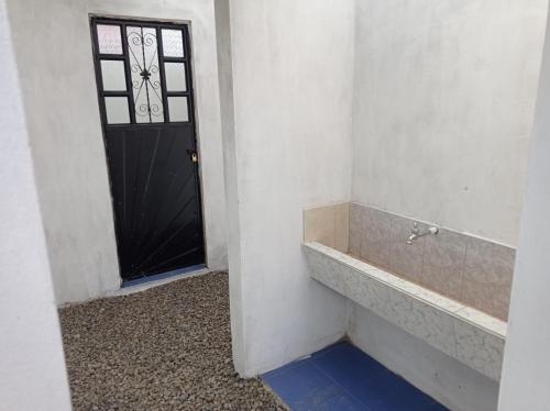 baño con puerta negra y ducha a ras de suelo en Camping Las Acacias, en Guatavita