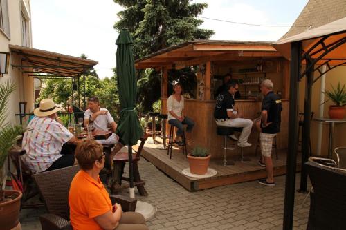 a group of people sitting at an outdoor bar at Pension Strohmer in Rust