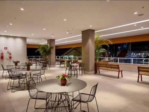 una hall con tavoli e sedie e una caffetteria di Resort Solar das Águas - Olímpia SP a Olímpia