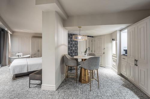a bedroom with a bed and a table and chairs at Le Capitole Hotel in Quebec City