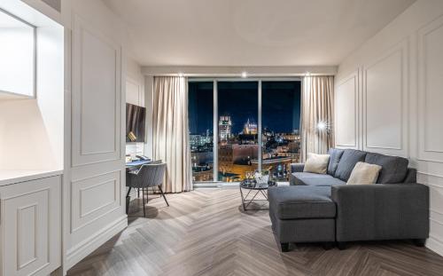 ein Wohnzimmer mit einem Sofa und einem großen Fenster in der Unterkunft Le Capitole Hotel in Québec